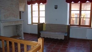 A room with a fireplace, a wooden bench, and a window with a radiator. - Historic XIV Century Cottage with Modern Comforts, Garden and Parking (Void-Vacon)
