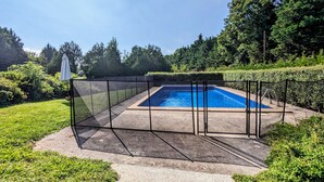 Ein rechteckiger Pool mit schwarzem Zaun und einer Betonplattform.