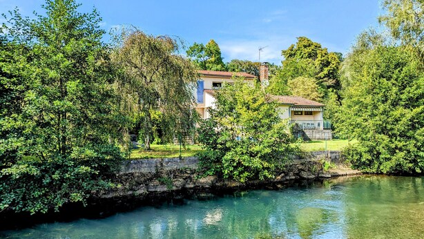 Ein Haus mit Garten und Teich.
