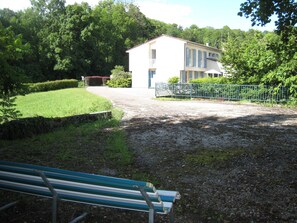A building with a white facade and blue shutters, surrounded by greenery and a gravel path. - Riverside Retreat: Heated Pool, Tennis, 5 Bedrooms, Private Parking (Haironville)