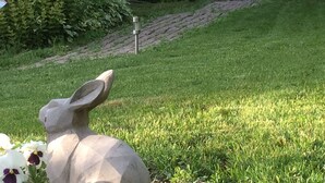 Un espace jardin agrémenté d’une statue en pierre, d’un mur en pierre et d’une pelouse.