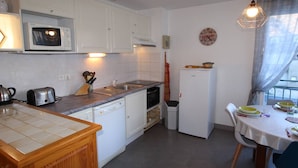 A compact kitchen with white cabinets, a microwave, a toaster, and a small refrigerator. - Central Apartment near Spa, 2 Bedrooms, Sleeps 6, Parking Included (Bagnères-de-Luchon)