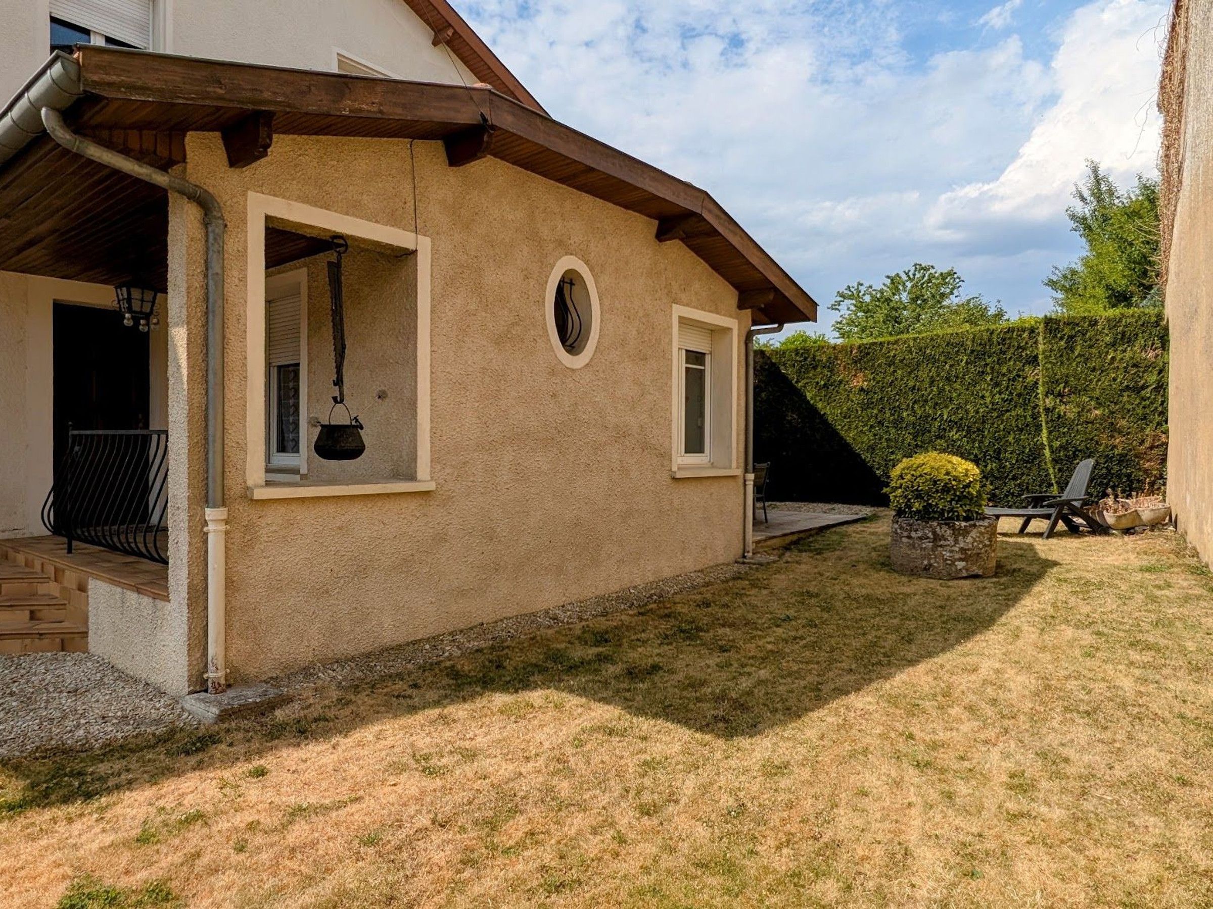 Une maison dotée d’un porche abrité, d’une petite fenêtre et d’une pelouse bien entretenue.