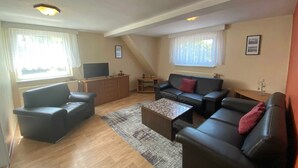 A living room with a sofa set, a coffee table, a TV, and a fireplace.