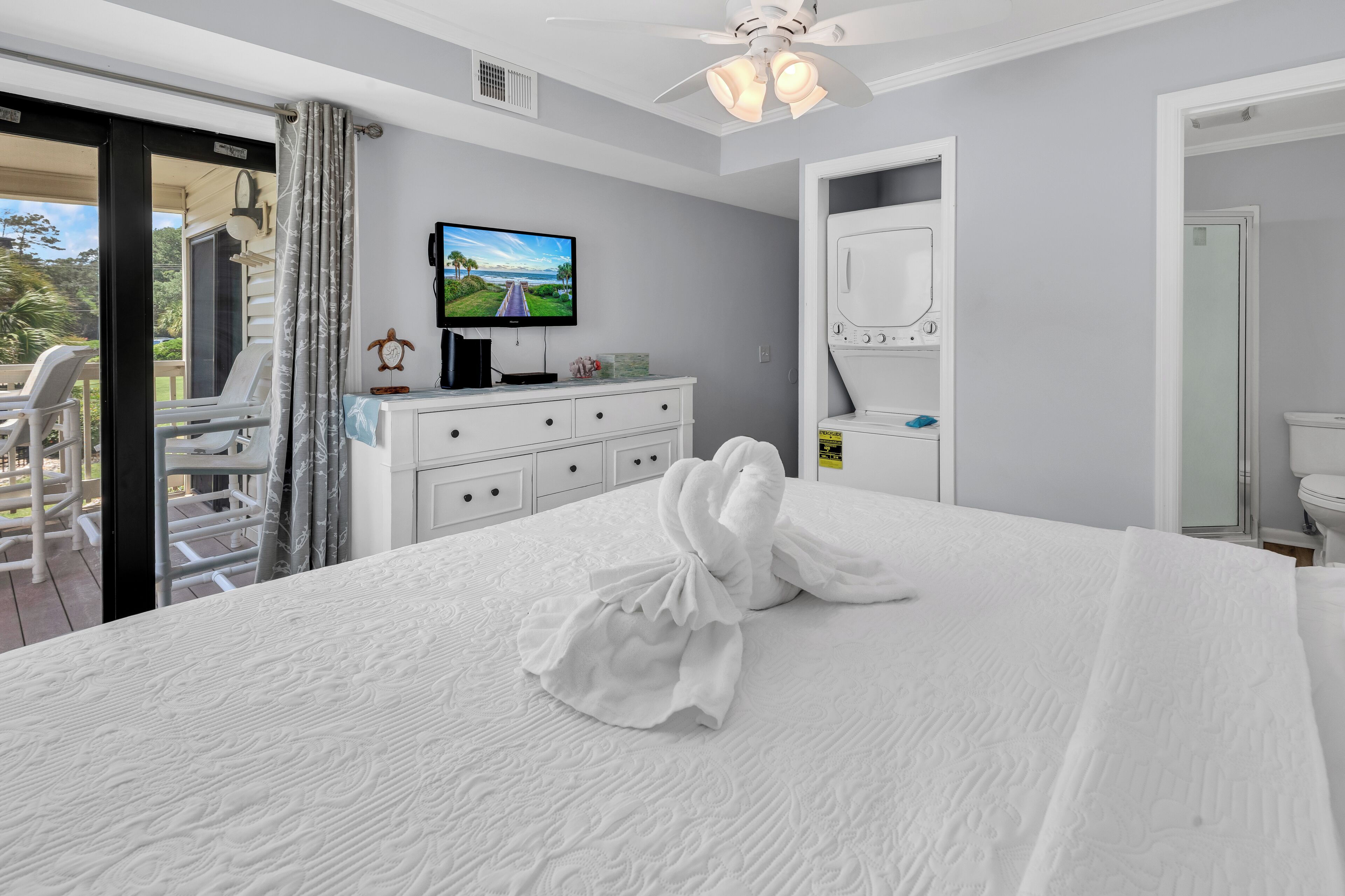 A hotel room with a bed, a television, a desk, and a bathroom.