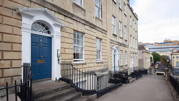 A narrow street with a blue door and a black metal fence. - Charlotte Rise (Bristol)