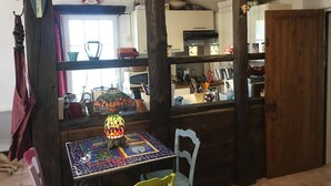 Una cocina rústica con vigas de madera, una mesa con azulejos y una lámpara de mosaico colorido.