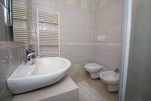 A bathroom with a large sink, a toilet, and a bidet.