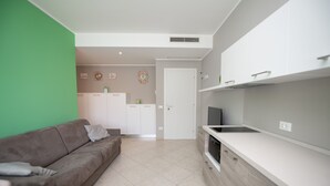 Een moderne keuken met witte kasten, een inbouwoven en een groot raam.
