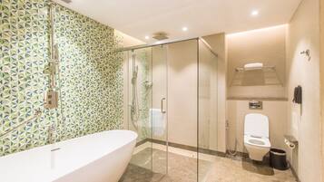 A modern bathroom with a glass-enclosed shower, a freestanding bathtub, and a toilet.