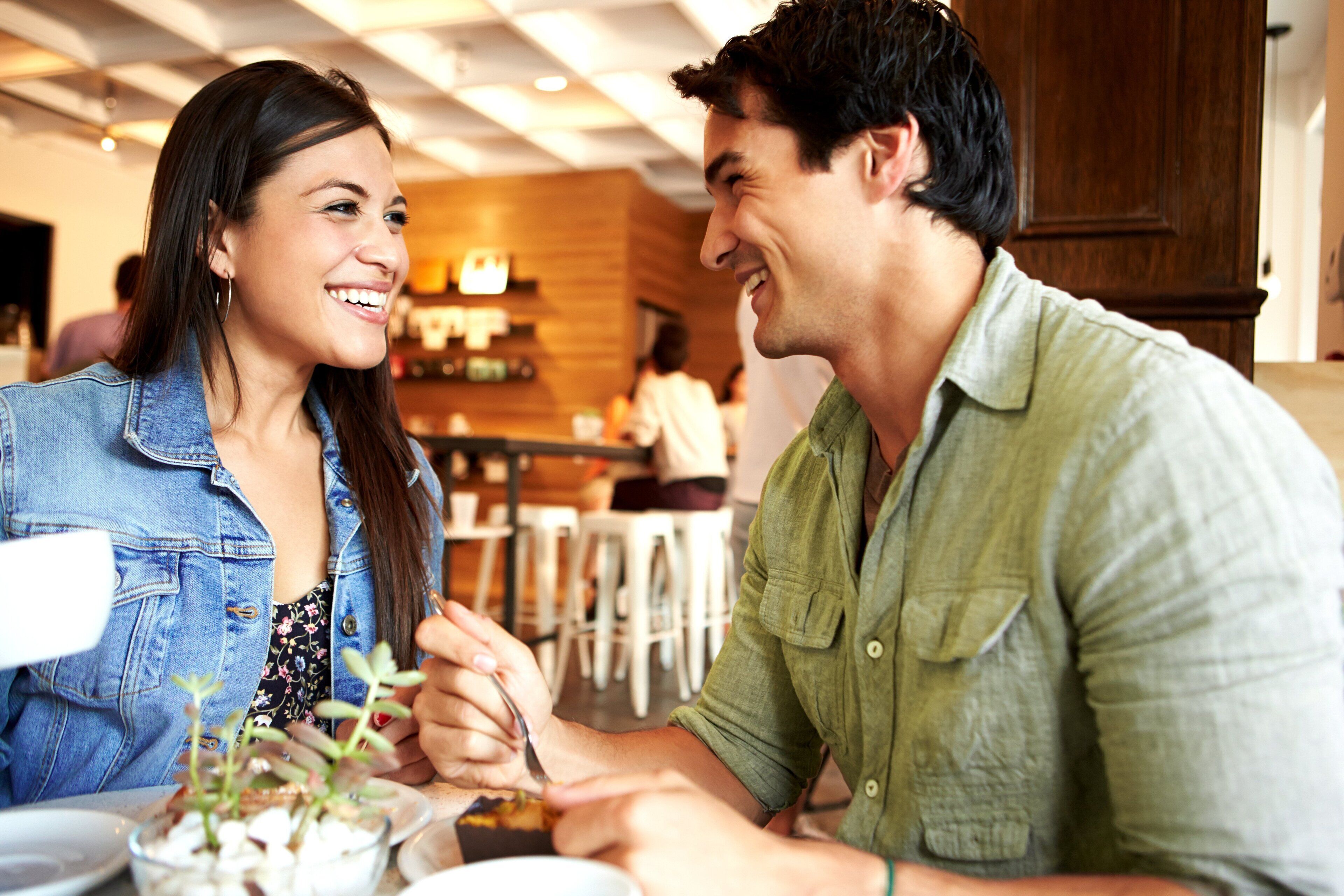 Una pareja cenando en un restaurante con una decoración moderna y detalles de madera.