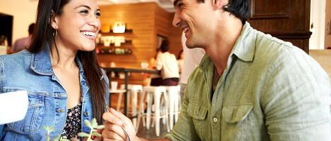 Una pareja cenando en un restaurante con una decoración moderna y detalles de madera.