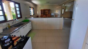 A kitchen with a gas stove, a sink, a large island, and a refrigerator. - Country house in a gated community in Itupeva. <br> (Itupeva)
