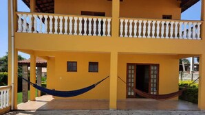 A yellow building with a balcony and two hammocks. - Country house in a gated community in Itupeva. <br> (Itupeva)