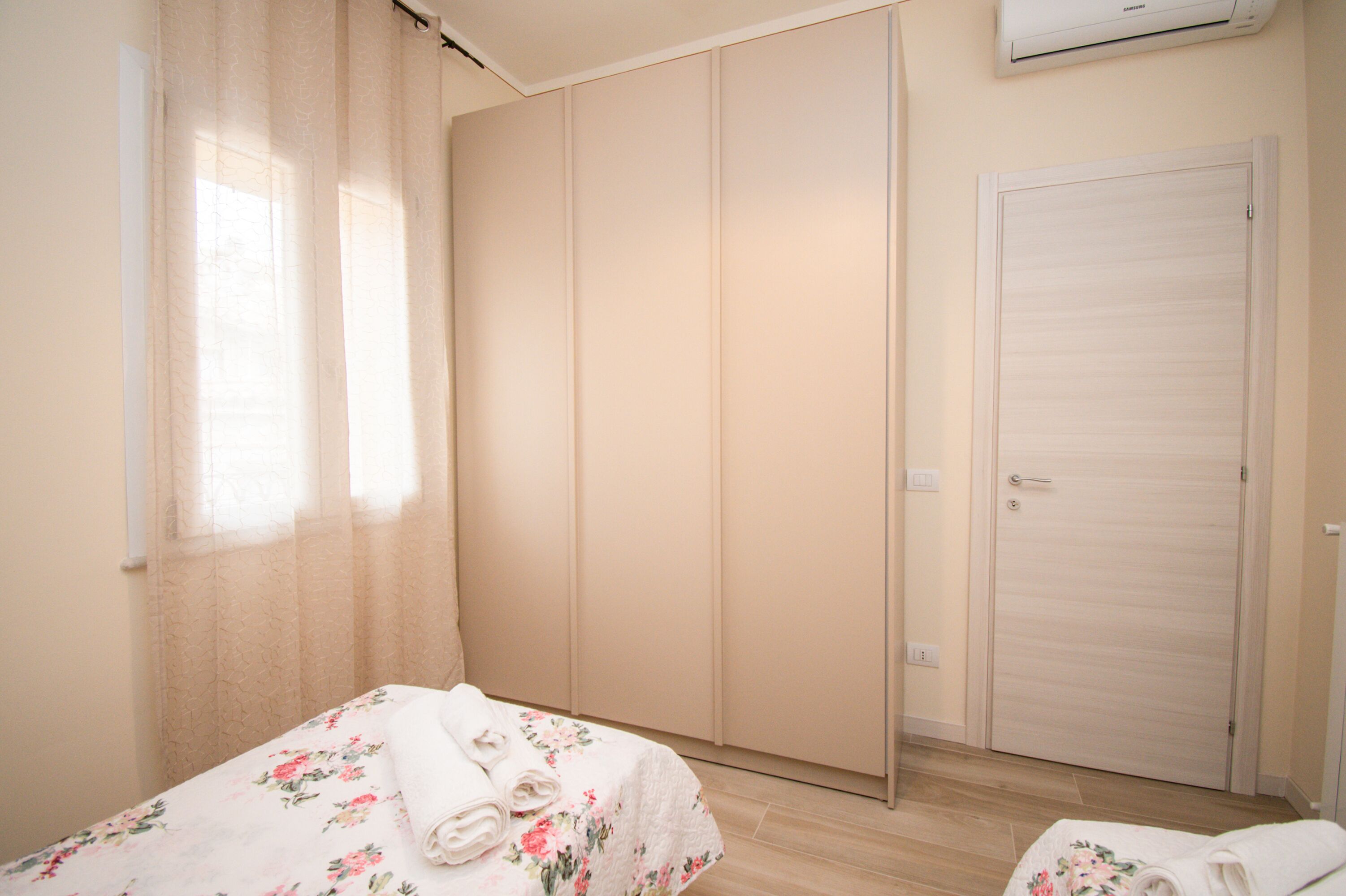 Une chambre à coucher avec un lit, une armoire et une porte.