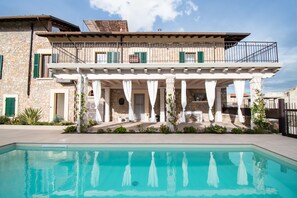 A two-story stone building with a pool in front. - Luxus Gardoncino (Manerba del Garda)