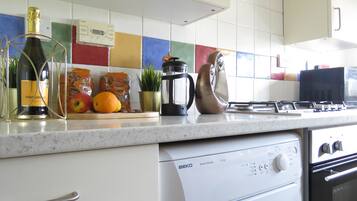 Deluxe Apartment | Private kitchen | Full-sized fridge, microwave, electric kettle, dining tables