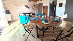 A dining area with a wooden table, blue chairs, and a black metal frame. - House 100m from the beach and 500m from the port of St Jacques, les gîtes de Rhuys  (Sarzeau)