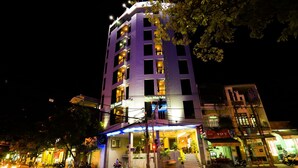 A multi-story hotel with a modern design, featuring a prominent entrance with a glass facade and outdoor seating area. - Big Home Hotel (Da Nang Municipality)