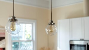 A kitchen with two hanging light fixtures and a microwave. - Bright Bohemian Home w/ Parking + Deck Near Forsyth Park by Lucky Savannah (Savannah)