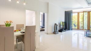 Een moderne woonkamer met een eethoek, grote ramen en uitzicht op het omliggende landschap.