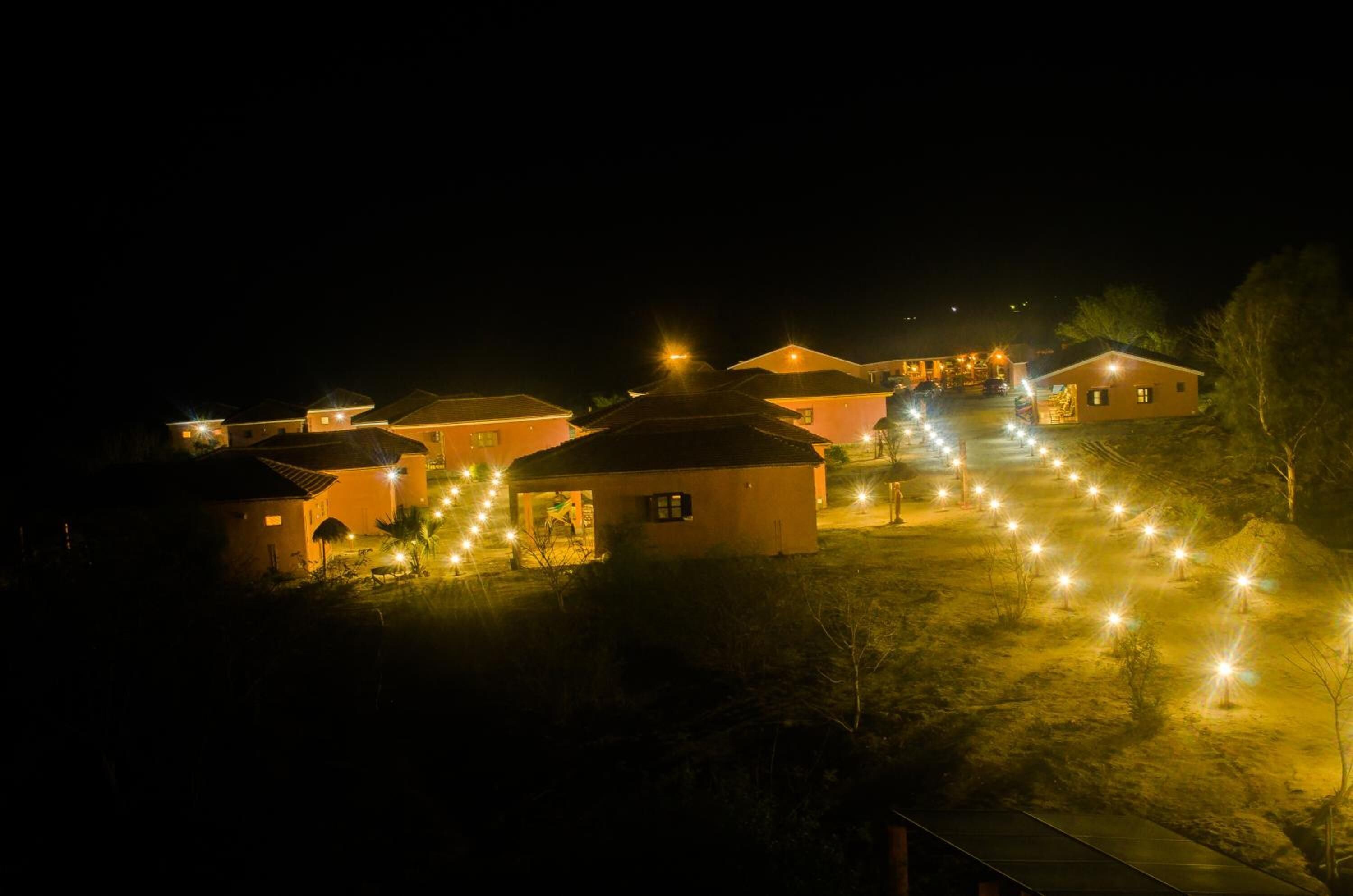 A series of small, uniformly designed buildings with a central pathway leading to a larger structure.