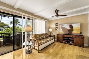 Een woonkamer met een bank, een televisie en een houten dressoir.