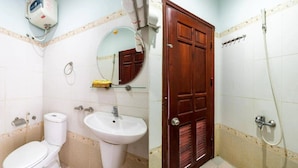 Ein Badezimmer mit Toilette, Waschbecken, Spiegel und Dusche.