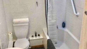 Une petite salle de bain compacte comprenant des toilettes, un bidet et une baignoire.