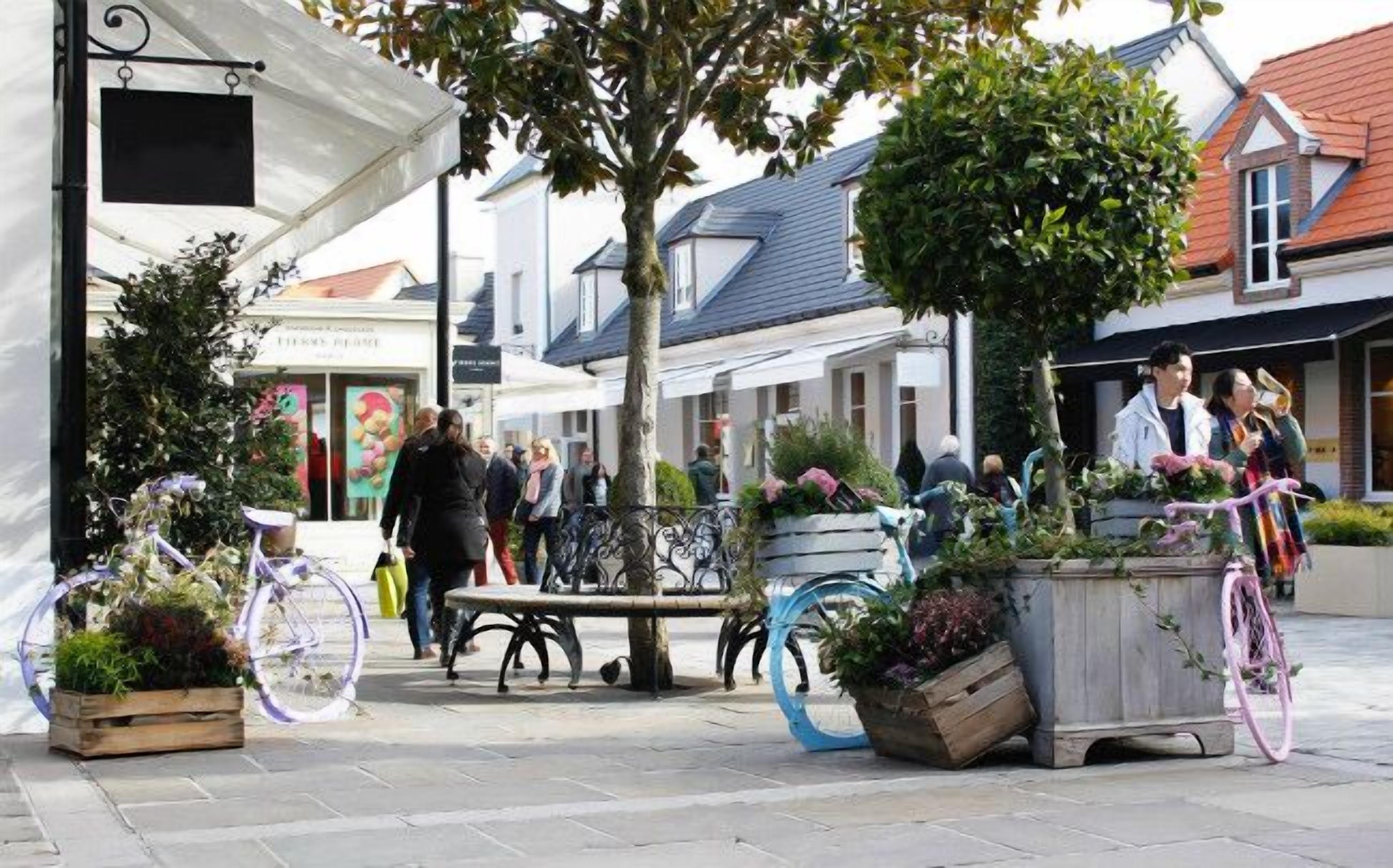 Escena callejera con una cafetería, mesas al aire libre y bicicletas.