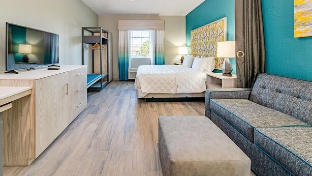 Une chambre d’hôtel équipée d’un lit, d’un canapé, d’une télévision, d’un bureau et d’une armoire.