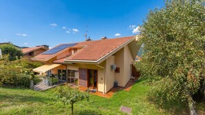 Une maison moderne avec un toit en pente, des panneaux solaires et un jardin bien entretenu.