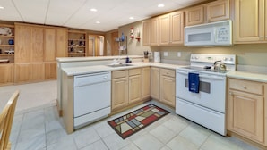 A kitchen with wooden cabinets, a microwave, a stove, and a dishwasher.