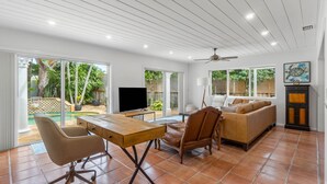 A spacious living area with a dining table, a sofa, and a TV.