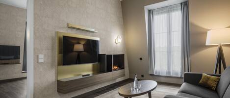Un salon moderne avec une cheminée, un téléviseur à écran plat, un canapé et une table basse.