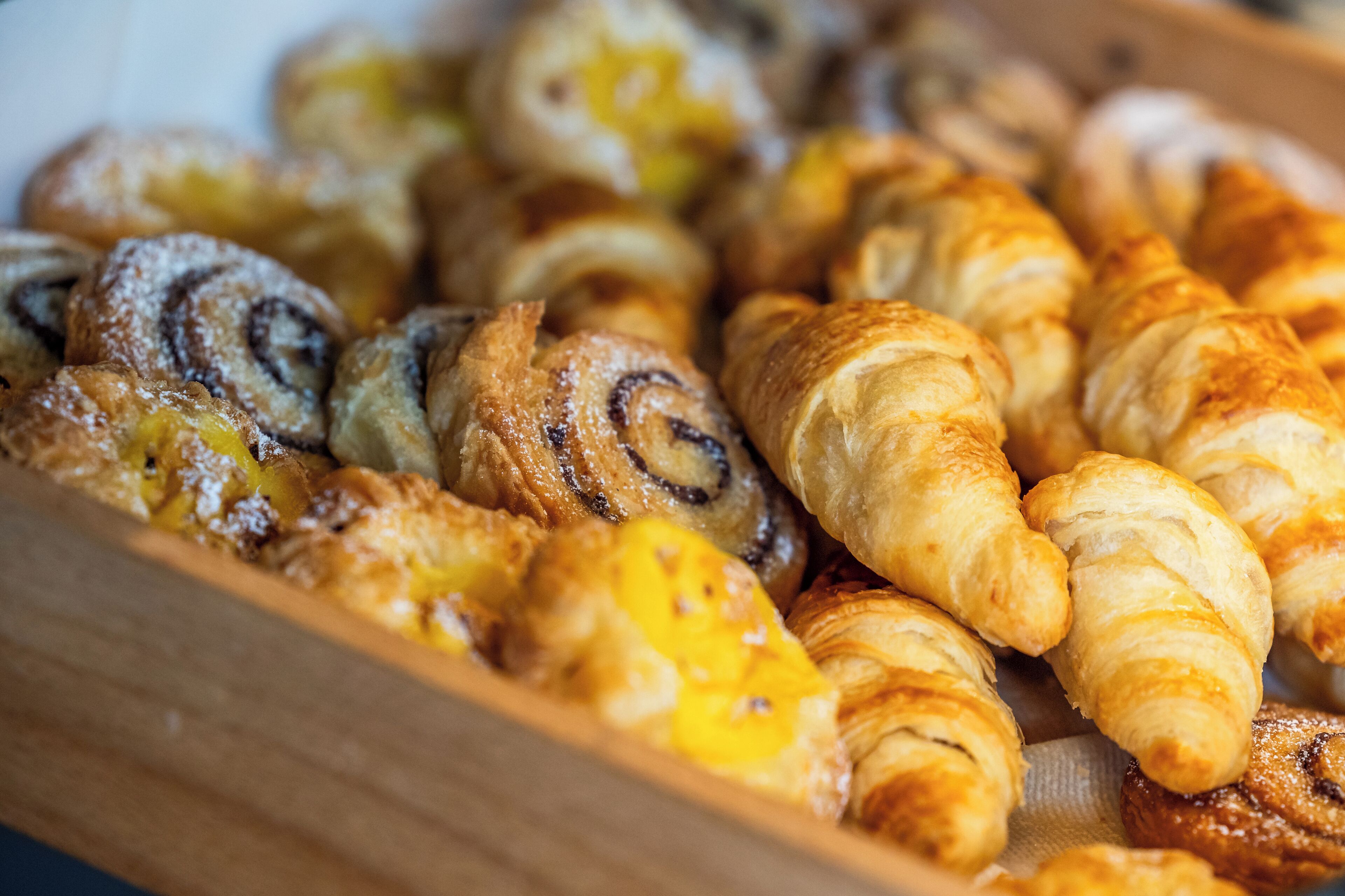 A variety of pastries including croissants and cinnamon rolls.
