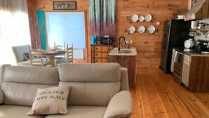 A cozy living room with a sofa and a dining area with a table and chairs. - Country Bliss (Tishomingo)