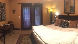 Une chambre d’hôtel équipée d’un lit, d’un bureau, d’une chaise, d’une télévision et d’une cheminée.
