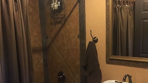 Une salle de bain équipée d’une baignoire, d’un lavabo et d’un espace douche.
