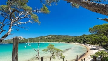 Una playa cerca, sillas reclinables de playa, toallas de playa