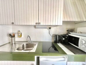 A kitchen with a sink, a Bosch coffee maker, and a microwave.