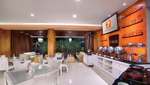A modern hotel lobby with a buffet area, wicker furniture, and a U-bar. - Sun Royal Hotel (Kuta)