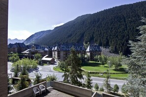 Vista di un edificio con tetto curvo, circondato da alberi e una montagna sullo sfondo.
