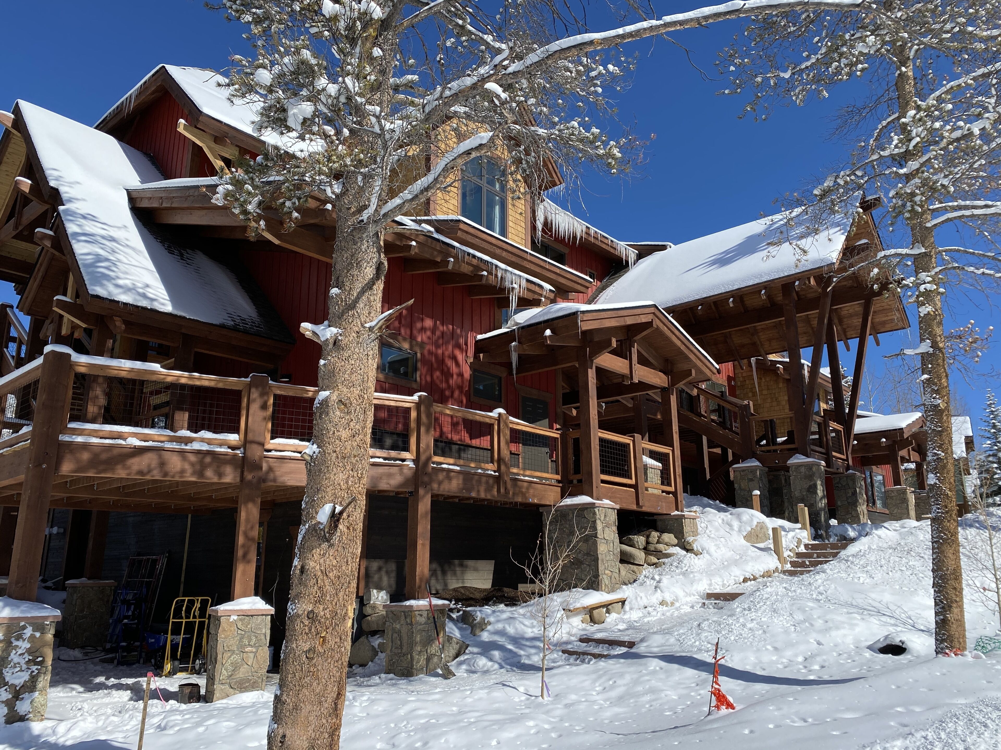 A wooden chalet with multiple balconies and a snow-covered roof.