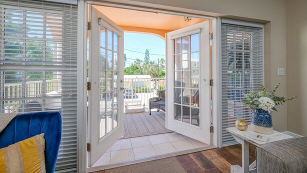 A room with a sliding glass door leading to a balcony with outdoor furniture.