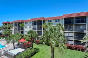 A multi-story hotel with balconies, a swimming pool, and landscaped gardens. - Condo# 119 Beautifull updated Condo Siesta Key (Sarasota)