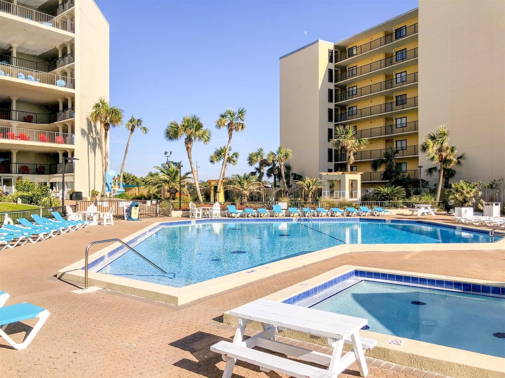 A pool area with multiple lounge chairs and a small pool.
