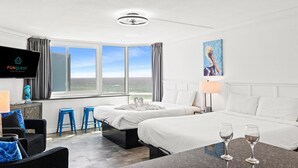 Une chambre d’hôtel avec deux lits, une télévision, un tableau et une vue sur l’extérieur.