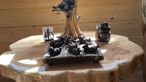 Et træbord med en bjørnefigur, en lampe og et glasbeholder.