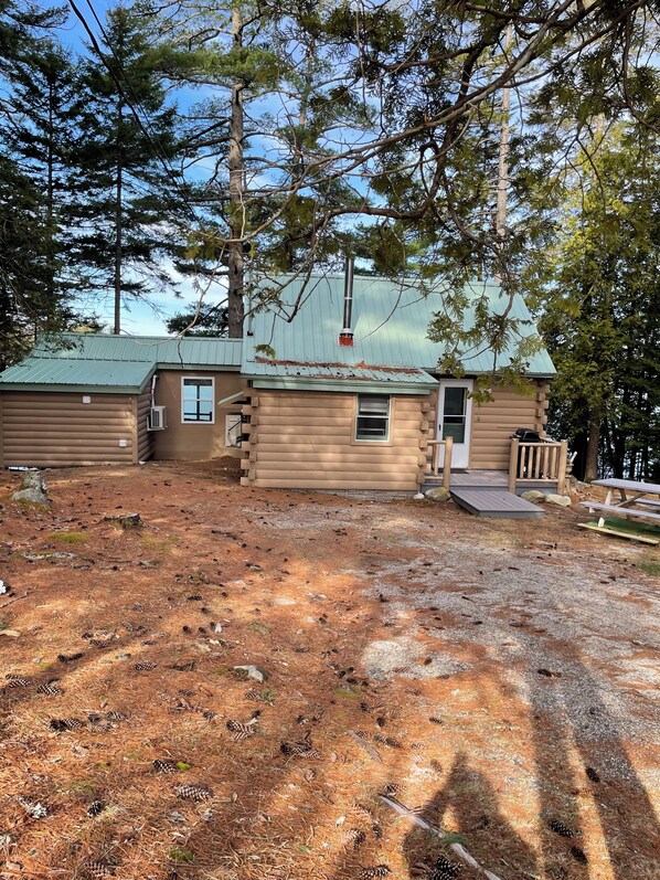 A cabin with a metal roof, a chimney, and a small porch. - Lakefront Cabin near Acadia National Park (Franklin)